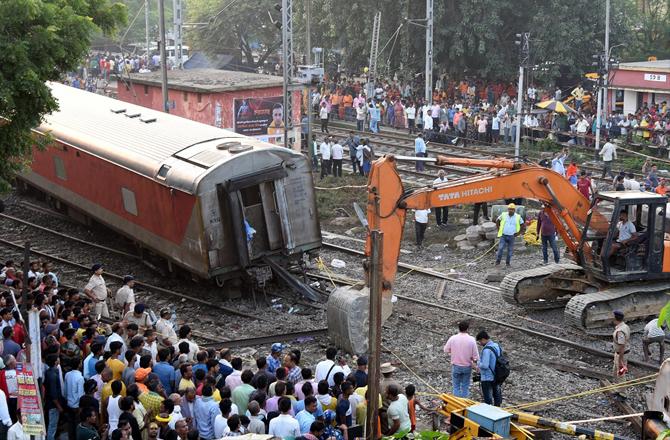 After the accident, the work of cleaning the track with the help of crane is going on. Photo: PTI